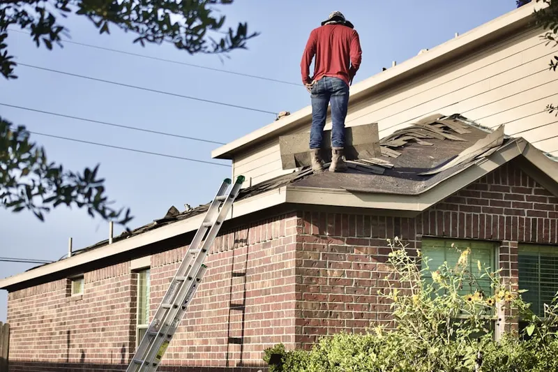 Professional roofer working on a residential roof in Linn-Crest Acres